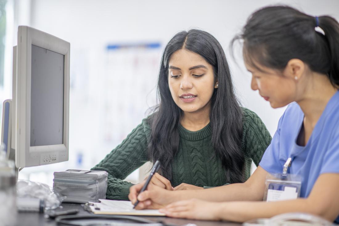 a hispanic girl at medical appointment with a doctor