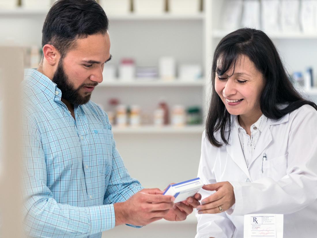 a man picking up medication in a pharmacy to treat penis sores. 