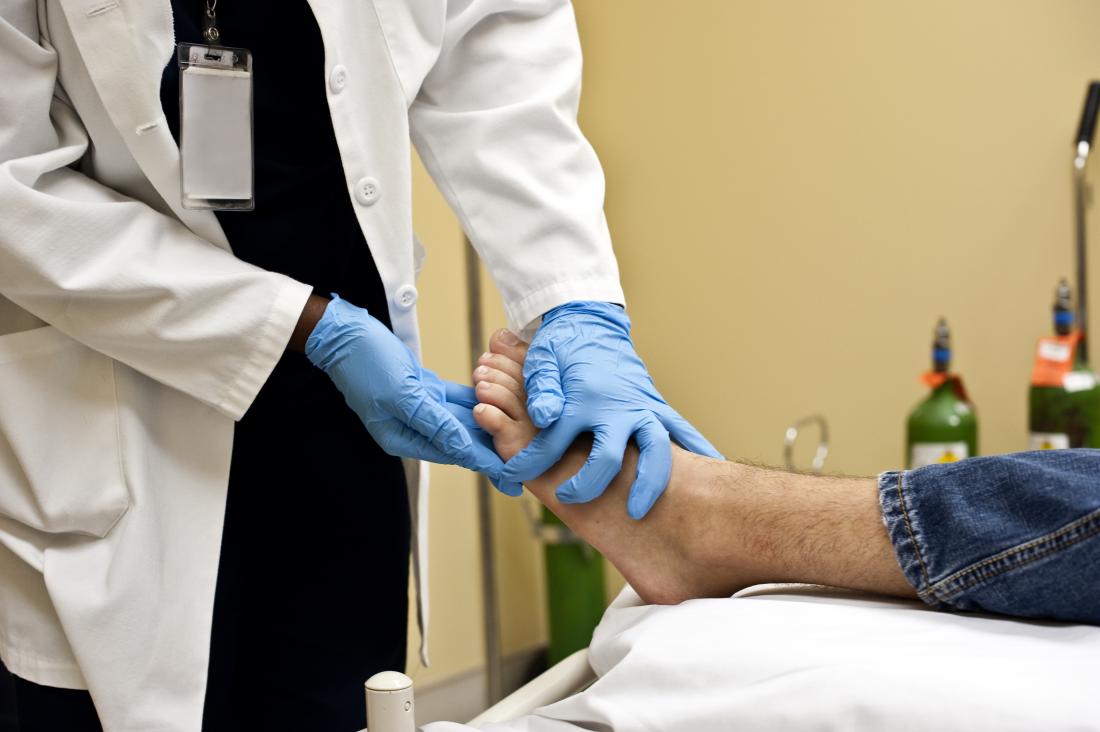 doctor feeling skin on bottom of patient s foot
