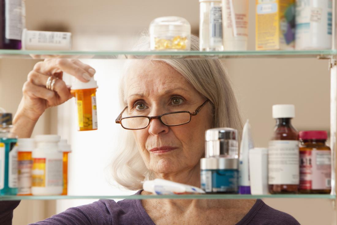 older woman lifting a pill container