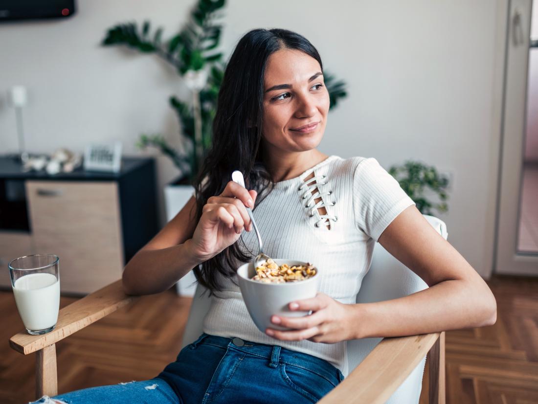 a woman enjoying a bowel of cereal. 
