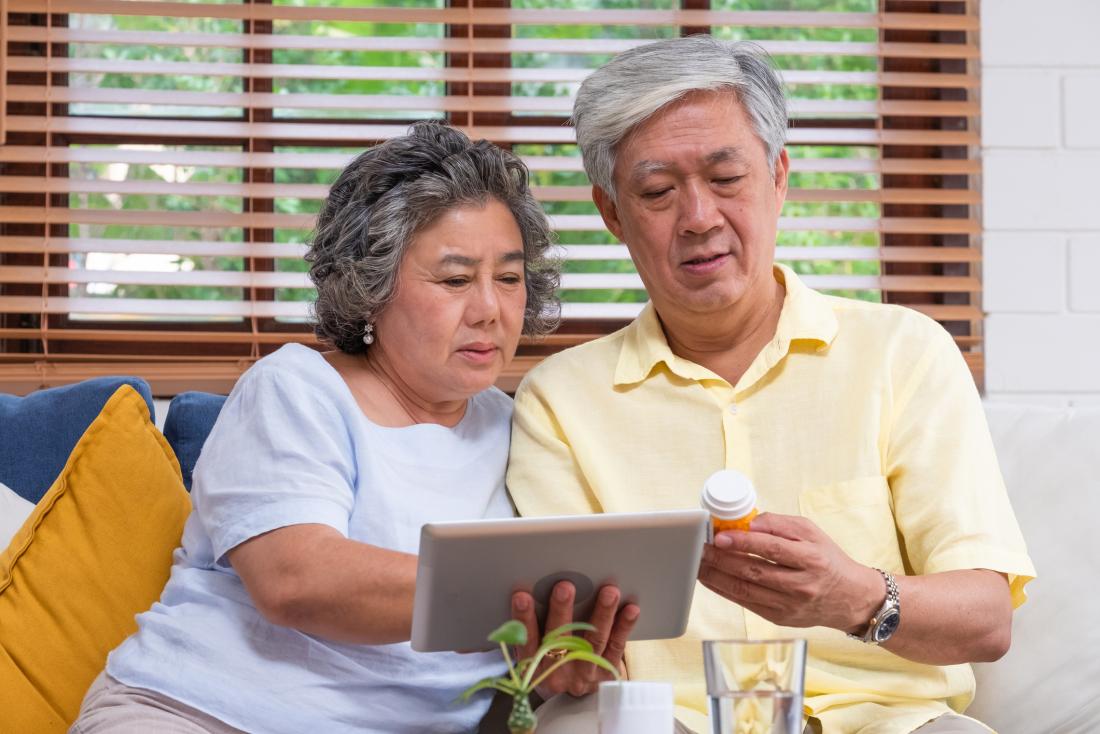 senior man and woman reading something on a tablet