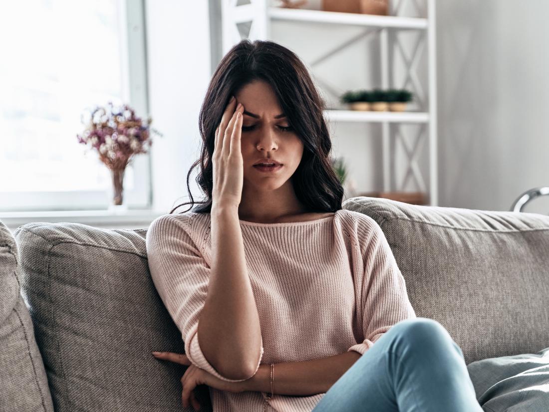 a woman experiencing a headache because of serotonin syndrome