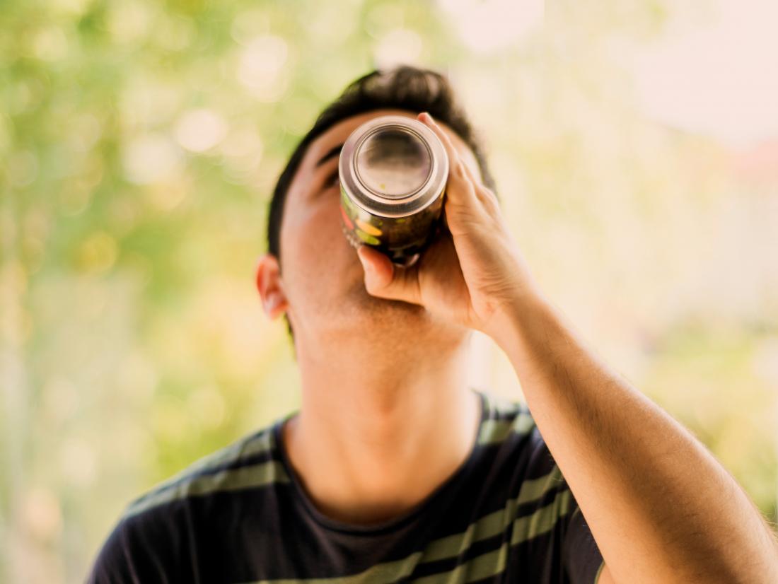 a man drinking a can of soda 