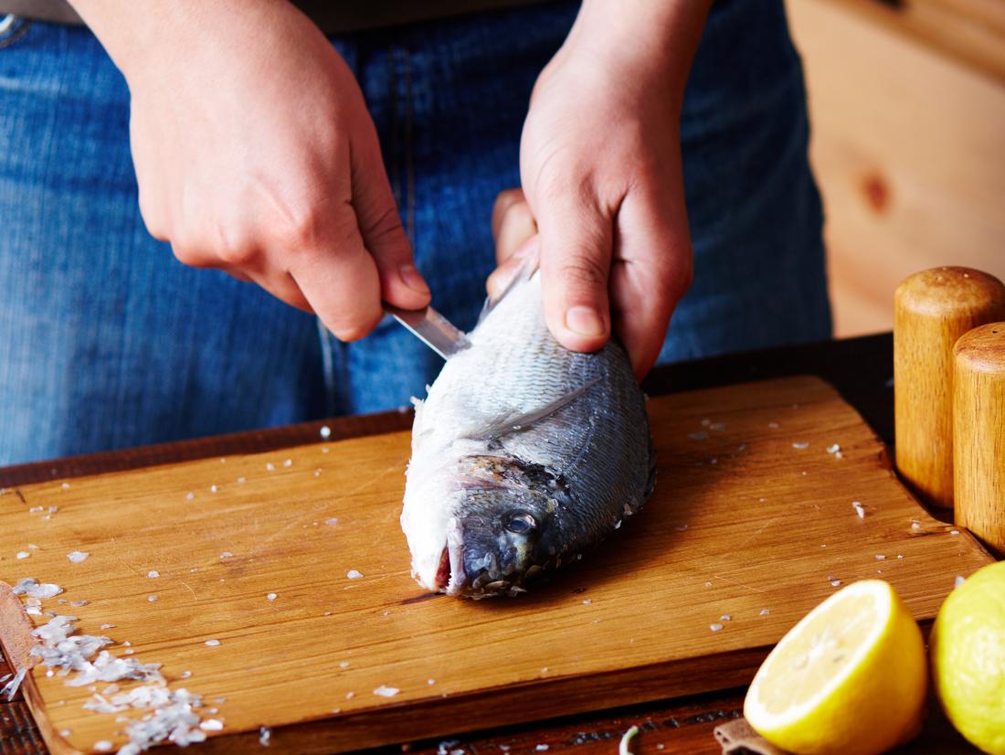 a man gutting a fish. 