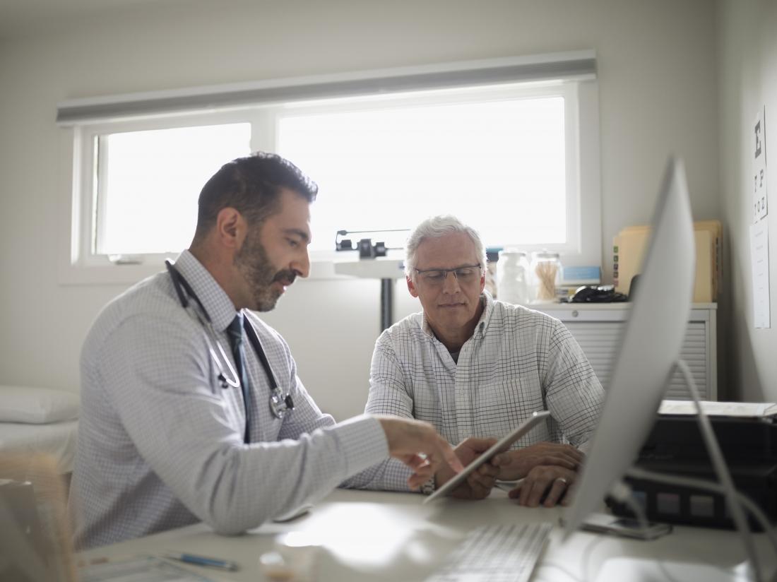 doctor showing clipboard to patient in office discussing immunodeficiency disorders