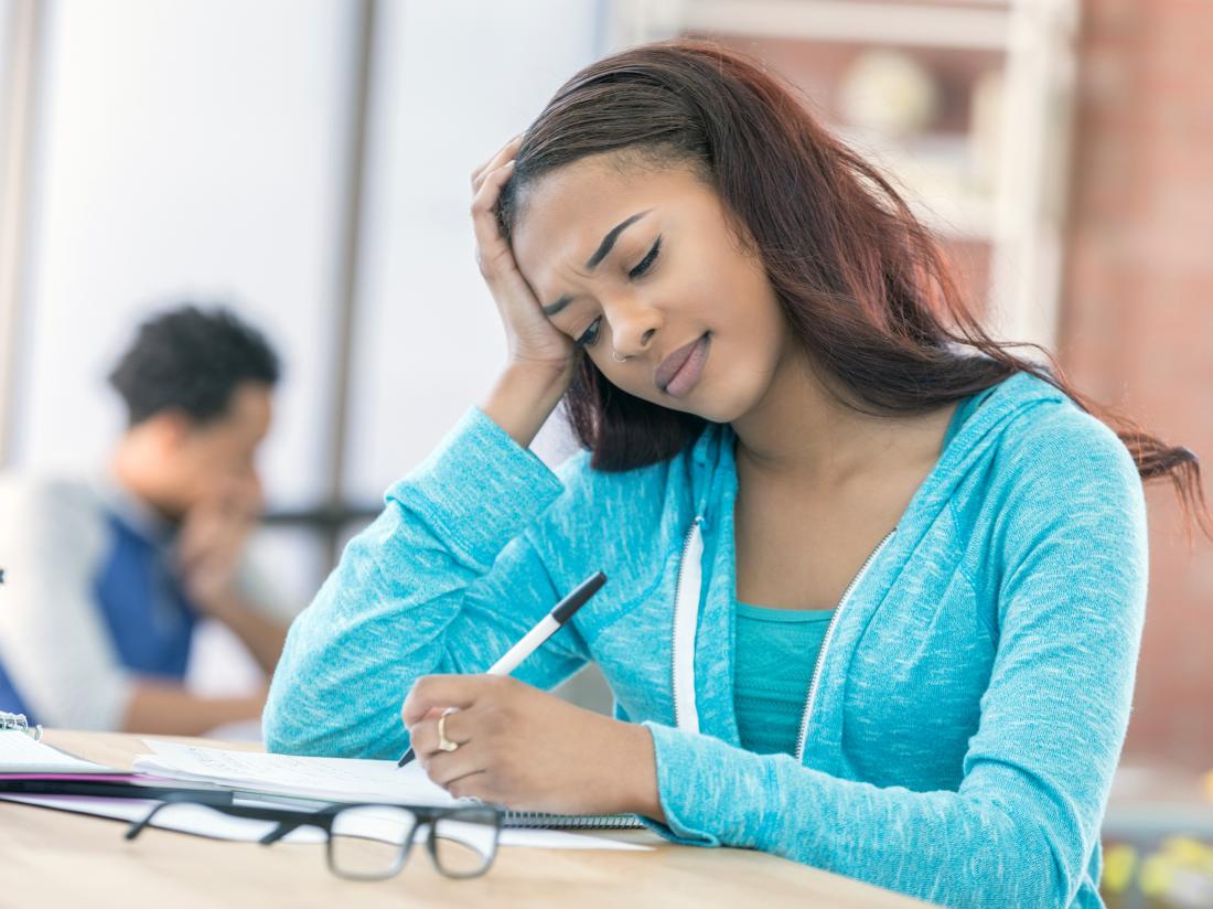 a young woman struggling to write. 