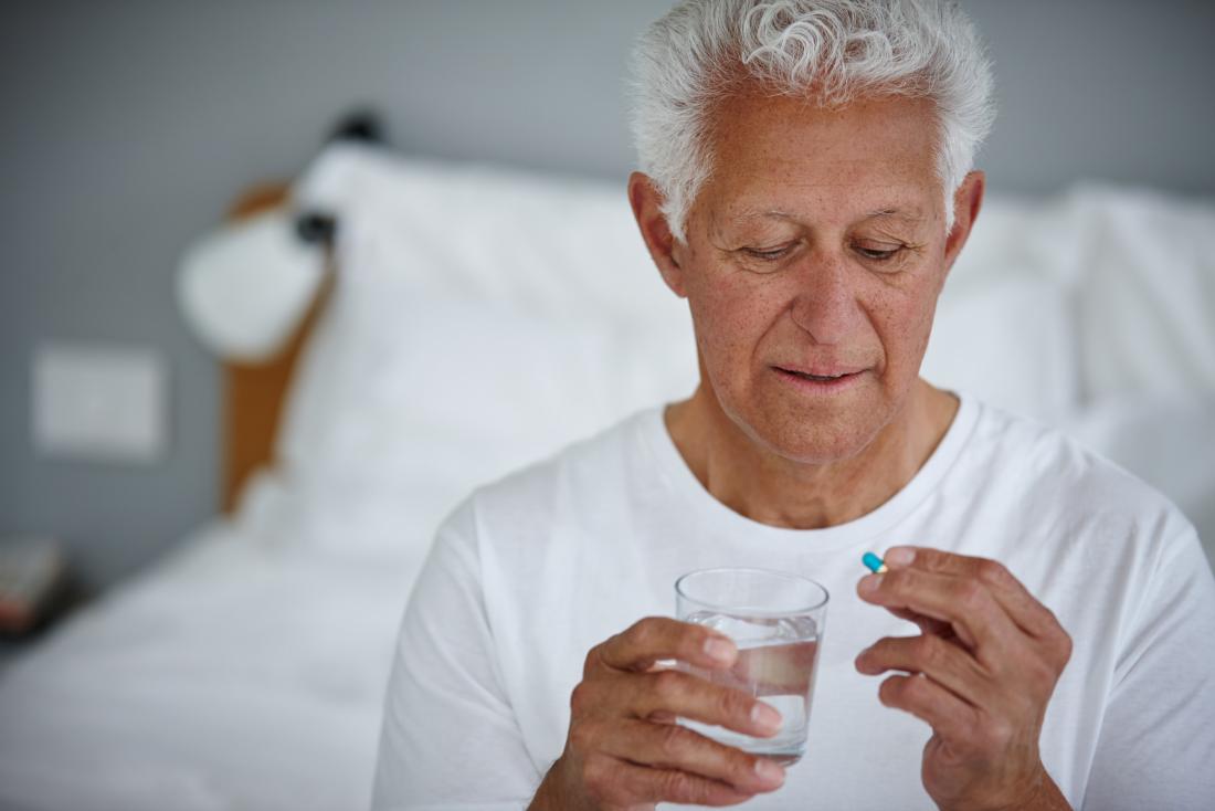 a man taking doxycycline with a glass of water