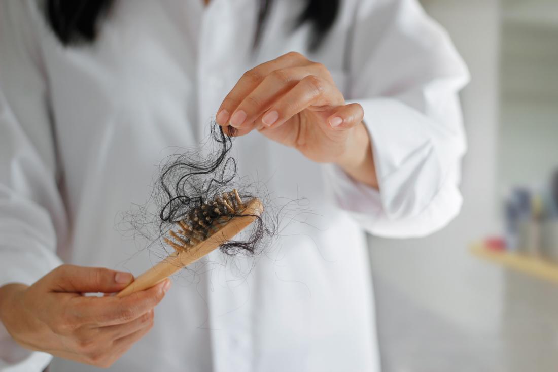 woman taking hair off a brush