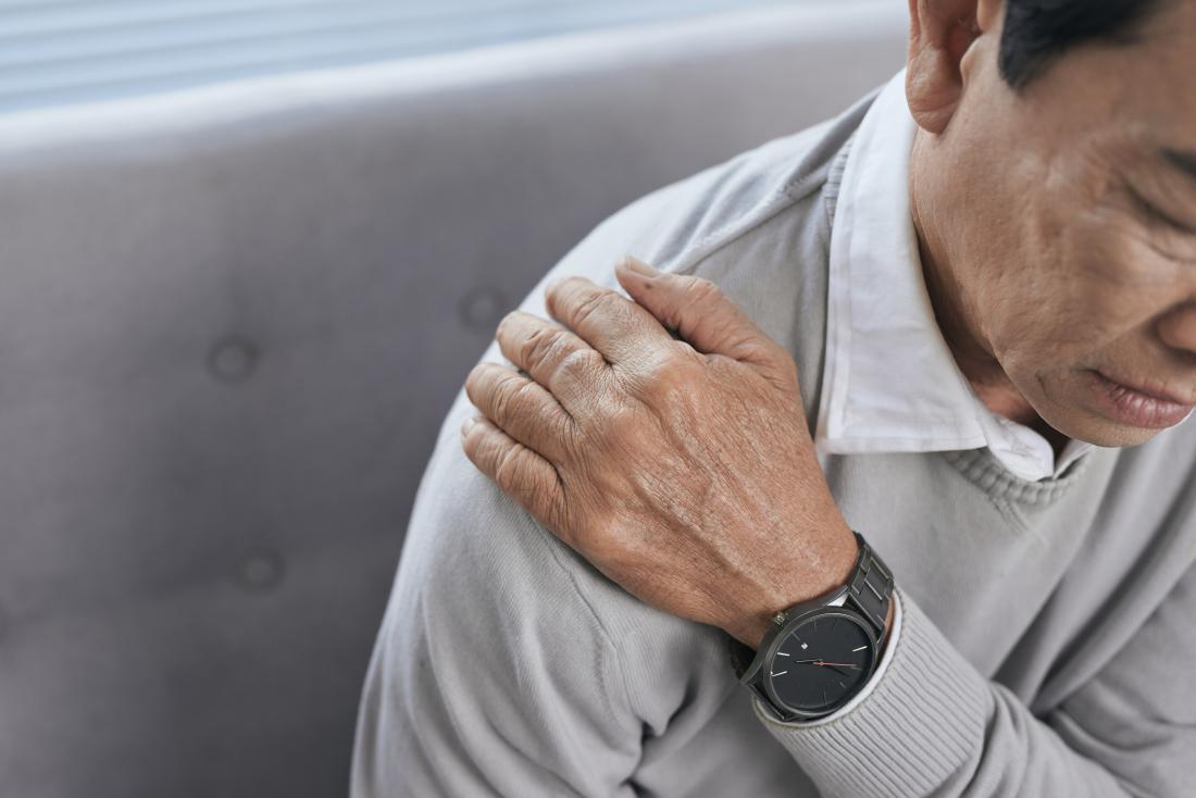 senior man holding shoulder because of joint pain