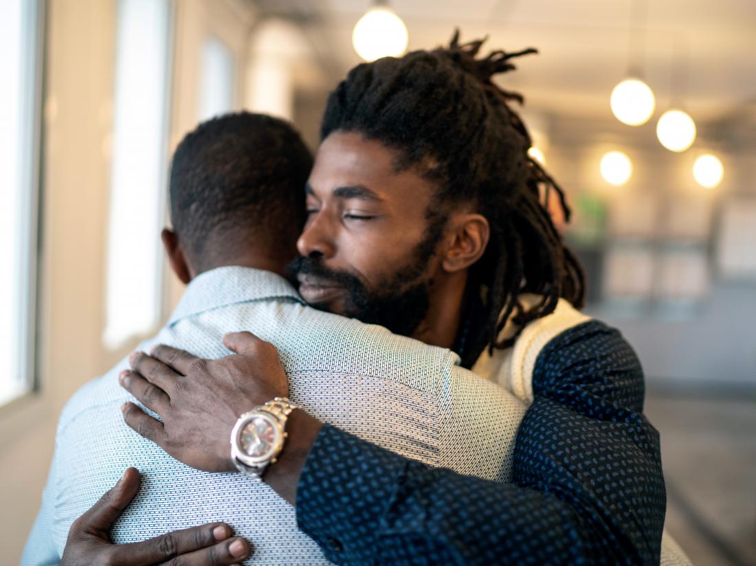 two men embracing in a room. 