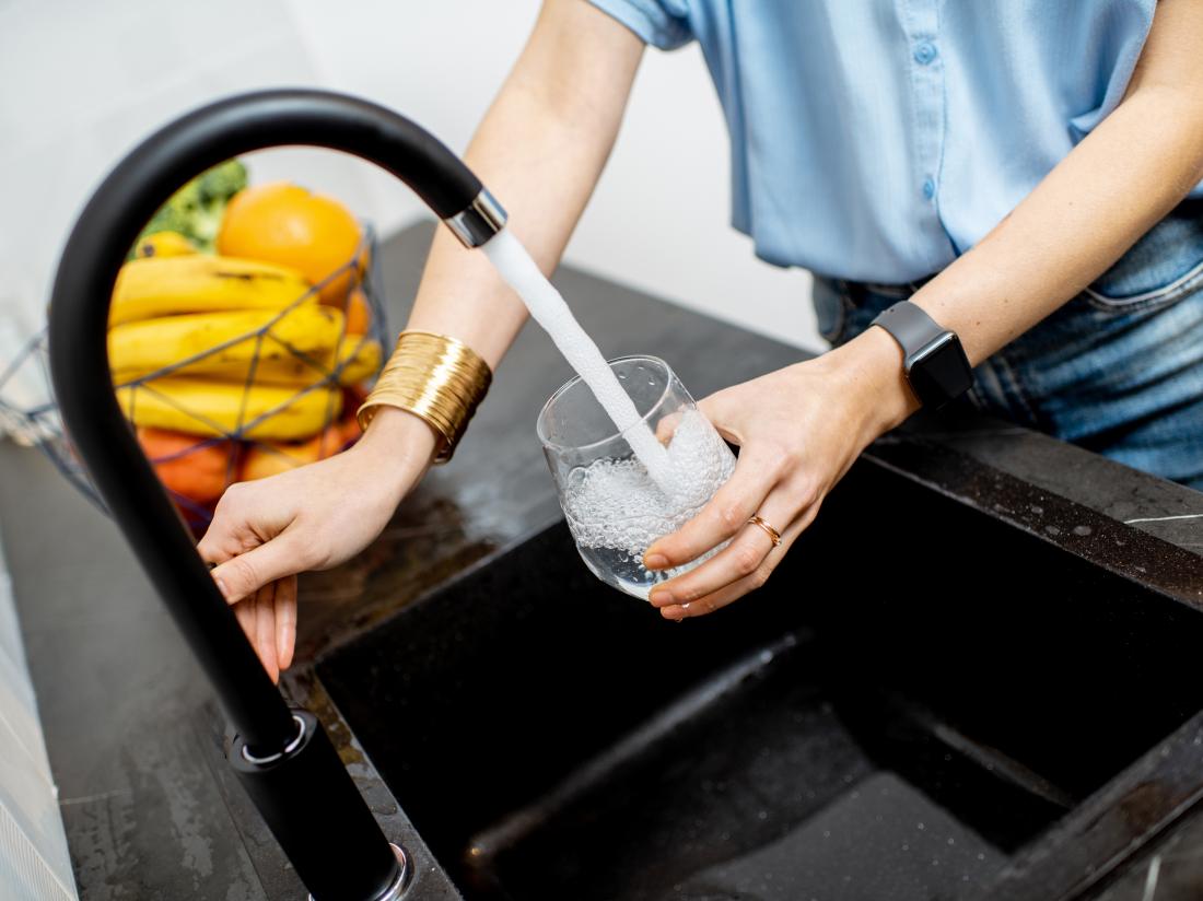 a woman pouring a glass of water. 