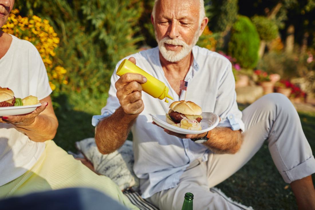 senior eating burger