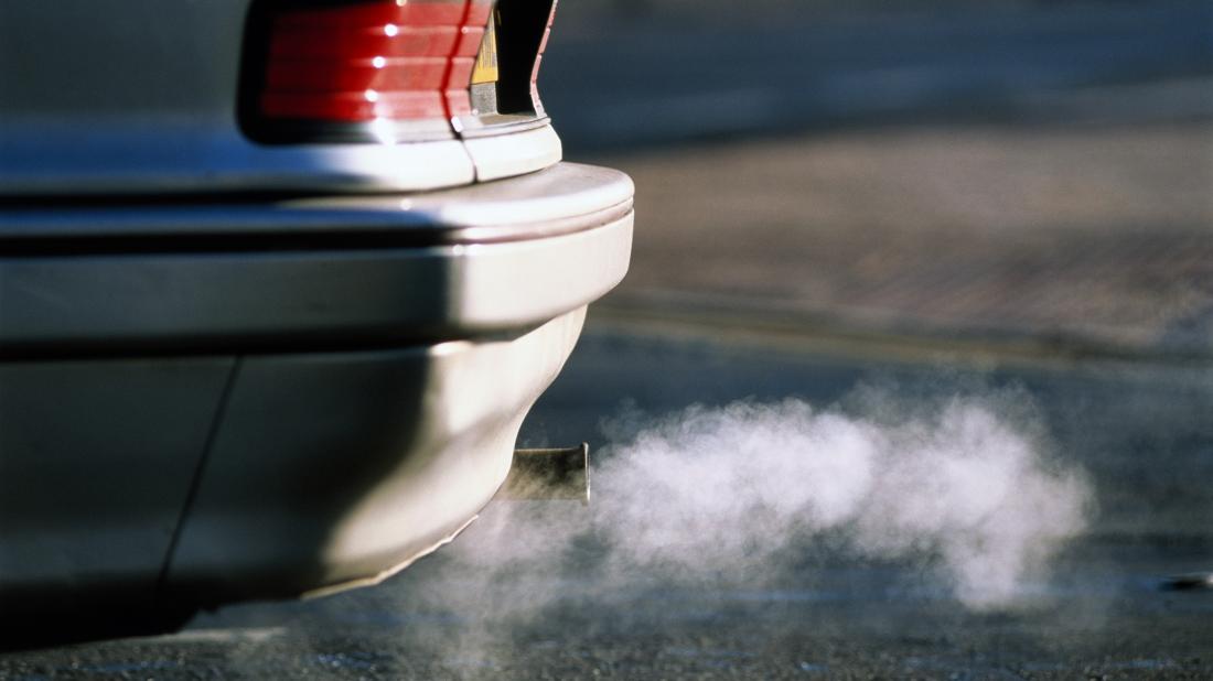 air pollutants coming out of a car exhaust pipe that may have negative health effects on the body